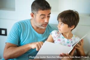 Dad With Child Reading In Bed by Javier Sanchez Mingorance from NounProject.com