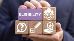 A stack of wooden blocks. One says “eligibility.” The others have icons of people, a question mark, and a checkbox.