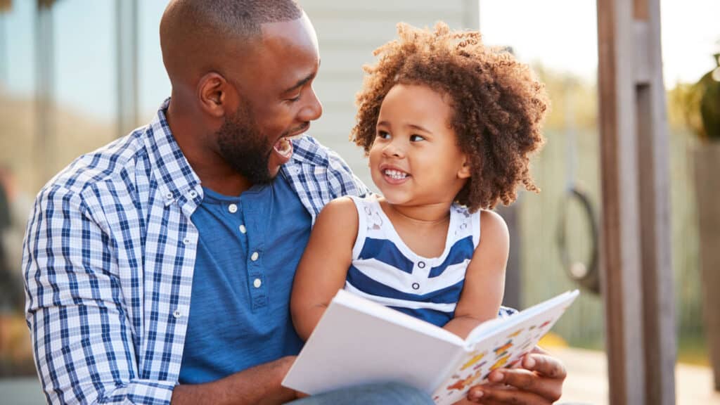 Young father helping his young daughter improve her reading and literacy skills