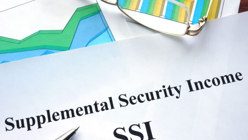 Supplemental Security Income (SSI) written on a paper with glasses sitting next to it.