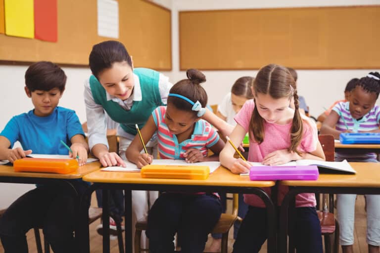 A specialist helps a student while they sit with peers in the regular classroom: an example of LRE