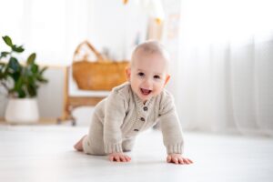 Young baby crawling and smiling.